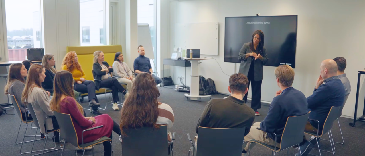 A facilitator leading a seated group through an Enliven session